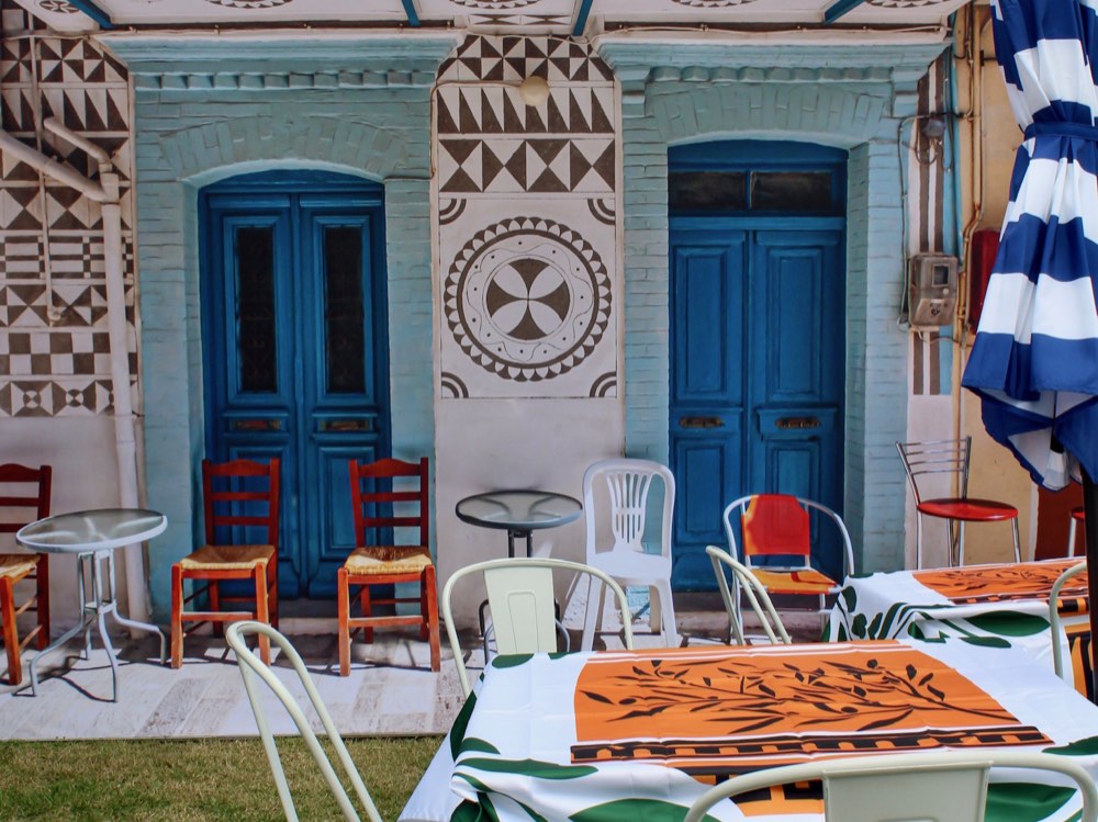 The 2023 Greek taverna themed booth with blue doors and olive-print tablecloths