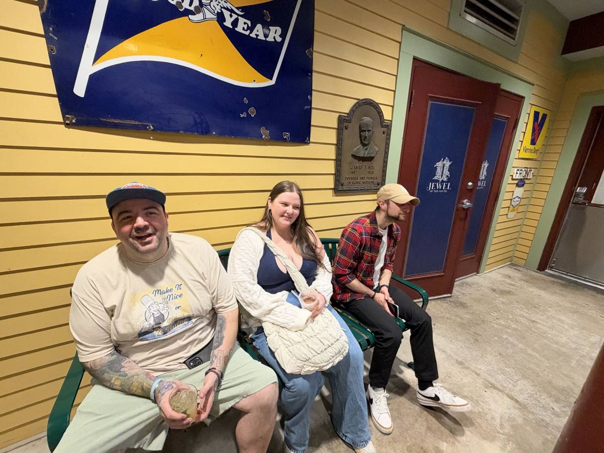 Guests relaxing on a bench along Parkway's yellow courtyard wall