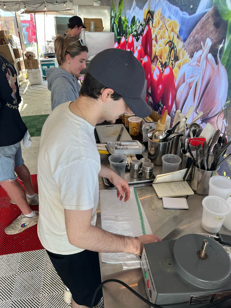 A volunteer prepping food in the booth